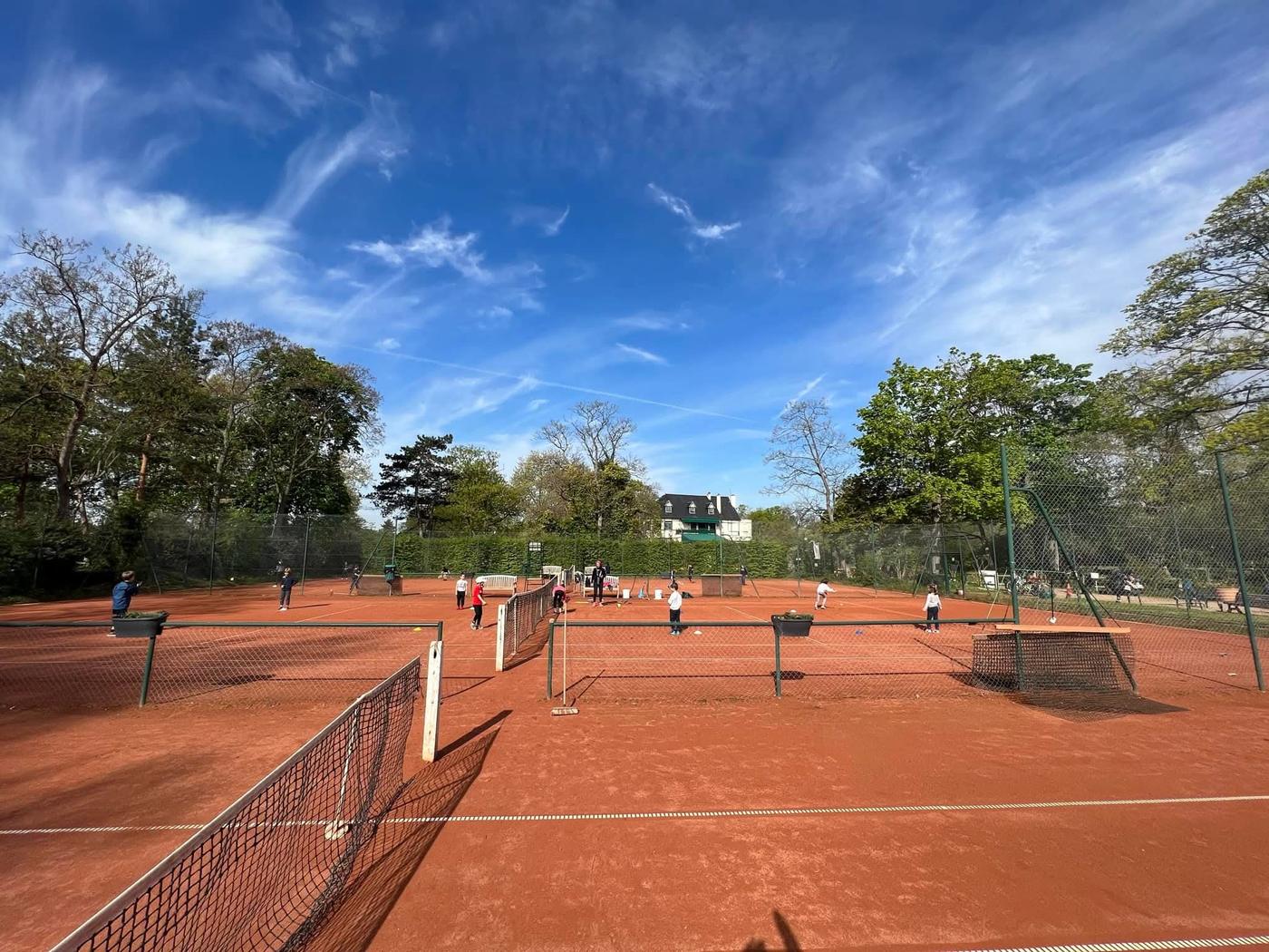 Les courts extérieurs en terre battue de l'Île des Ibis sous un ciel bleu